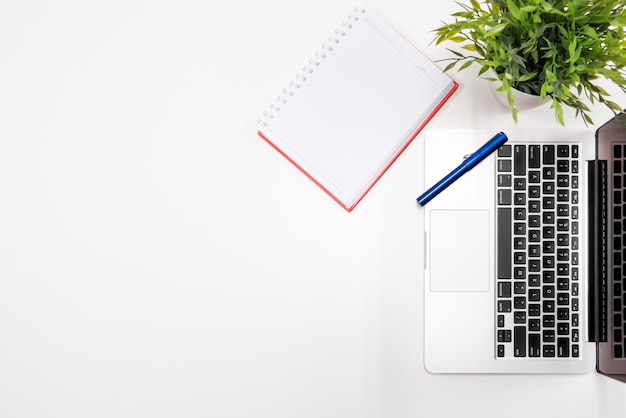 Bezpośrednio powyżej zdjęcia laptopa przez spiralny notebook na białym tle