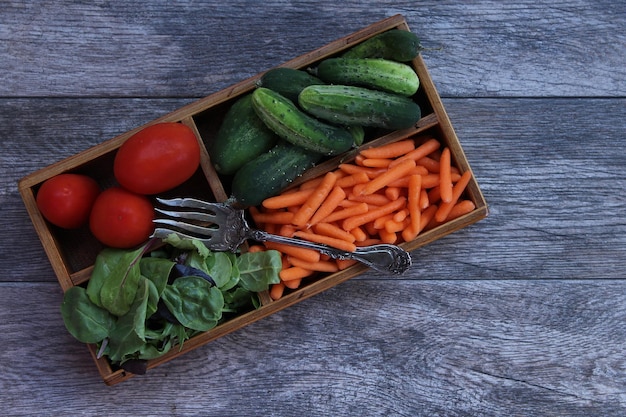 Zdjęcie bezpośrednio powyżej zdjęcie różnych warzyw w drewnianym pudełku na stole