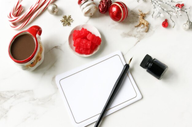 Zdjęcie bezpośrednio powyżej zdjęcie świątecznych dekoracji z czekoladą piórem i papierem na stole