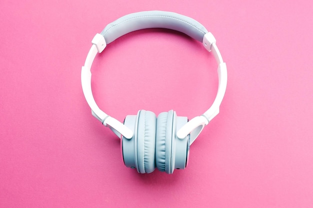Bezprzewodowe białe i szare słuchawki na różowym tle