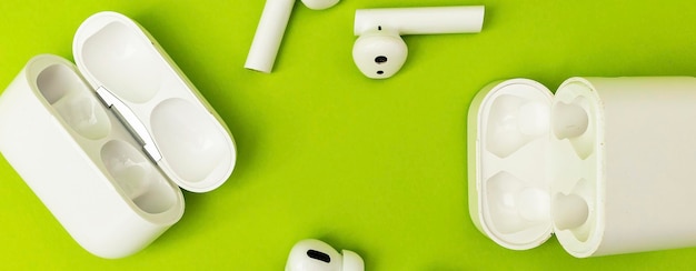 Bezprzewodowe słuchawki w kolorze białym na zielonym tle