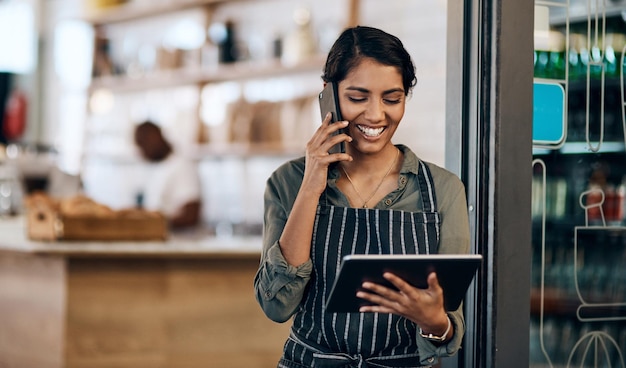 Bezprzewodowy barista Ujęcie młodej kobiety korzystającej z cyfrowego tabletu i smartfona podczas pracy w kawiarni