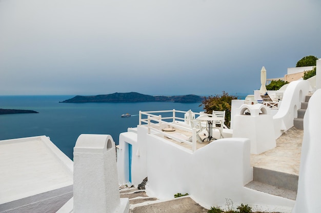 Biała architektura na wyspie Santorini, Grecja. Piękny krajobraz z widokiem na morze. Mglisty poranek.