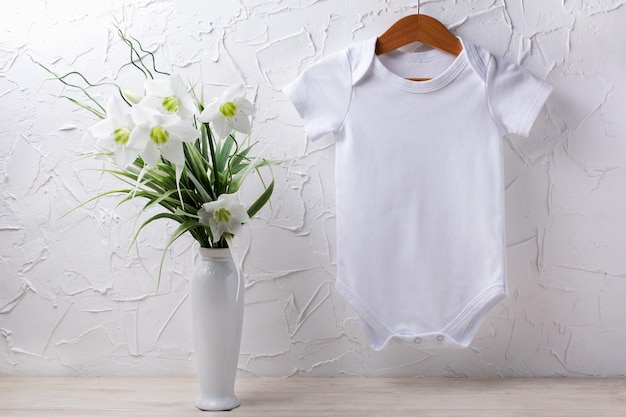 Zdjęcie biała bawełniana makieta onesie z krótkim rękawem z delikatnym bukietem lilii w wazonie zaprojektuj neutralne pod względem płci body szablon noworodka romper drukuj prezentację makiety
