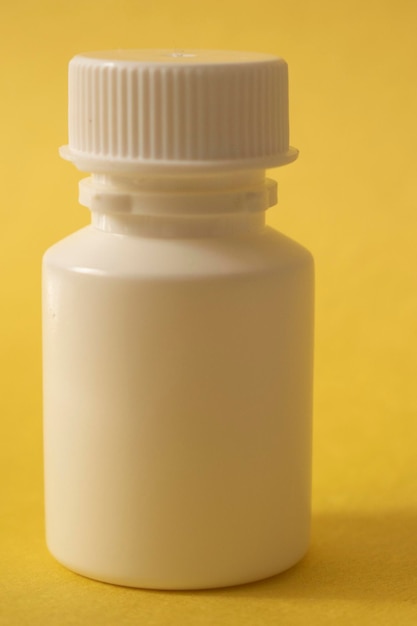 Biała butelka mleka znajduje się na żółtym tle.