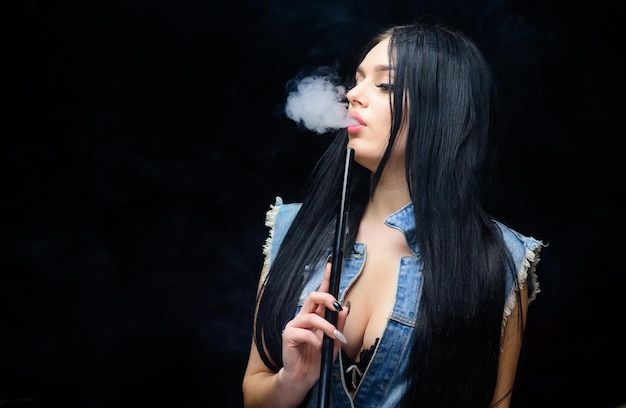 Biała chmura dymu Vaping jest seksowny Uzależnienie od nikotyny Atrakcyjna cycata brunetka paląca waporyzator Dziewczyna waporyzująca Szisza bar Elektroniczny papieros Modowa dziewczyna waporyzująca Relaks przy fajce wodnej