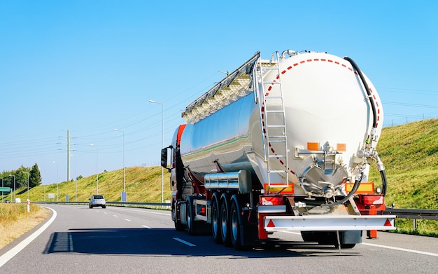 Biała cysterna magazynowa na autostradzie asfaltowej w Polsce. Biznesowa koncepcja przemysłowa.