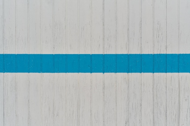 Biała drewniana ściana z niebieską linią z miejsca na kopię