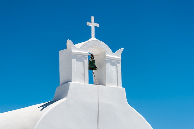 Biała dzwonnica i krzyż w Santorini