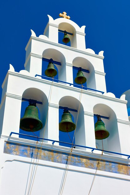 Biała dzwonnica w Oia na Santorini na tle błękitnego nieba, Grecja