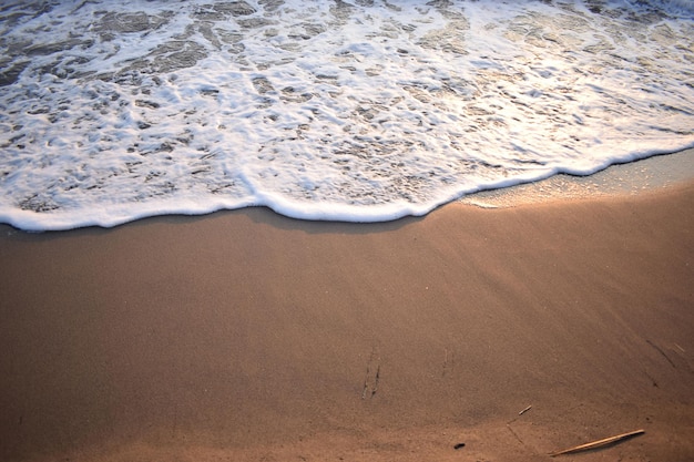 Biała fala błękitnego morza na piaszczystej plaży Naturalne tło