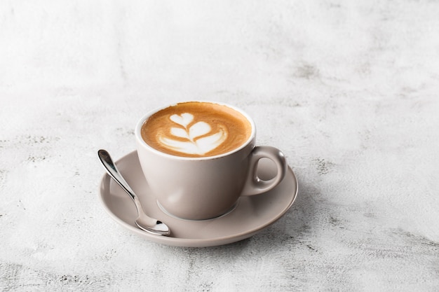 Biała filiżanka gorącej kawy latte z piękną pianką mleczną latte sztuki tekstury na białym tle na jasnym tle marmuru. Widok z góry, kopia przestrzeń. Reklama menu kawiarni. Menu kawiarni Poziome zdjęcie.