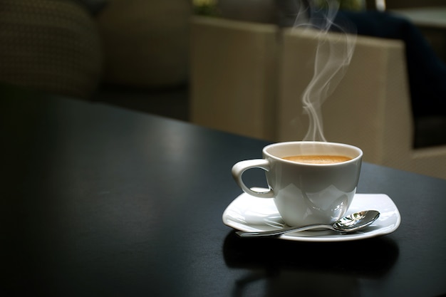 Biała filiżanka kawy Umieszczona na drewnianej podłodze