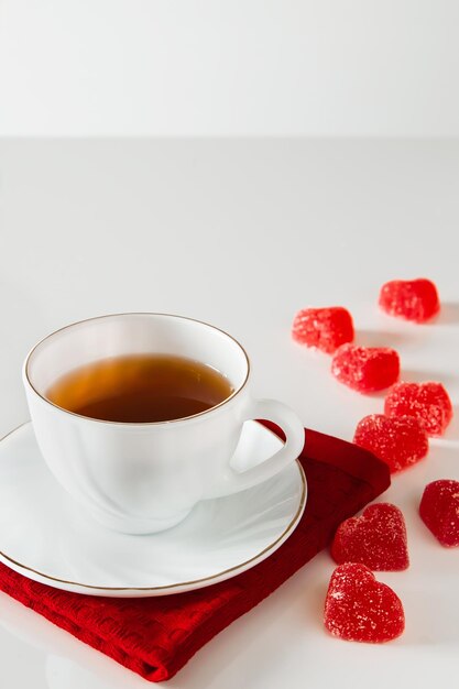 Biała filiżanka z herbatą na czerwonej pielusze