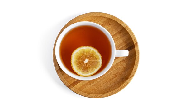 Biała filiżanka z herbatą na drewnianym spodeczku na białym tle