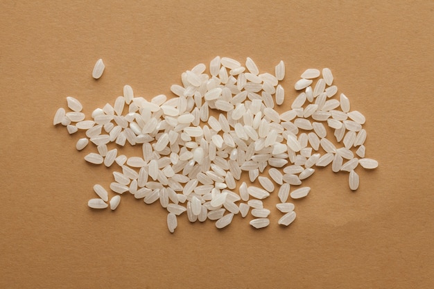 Biała garść ryżu na brązowej powierzchni