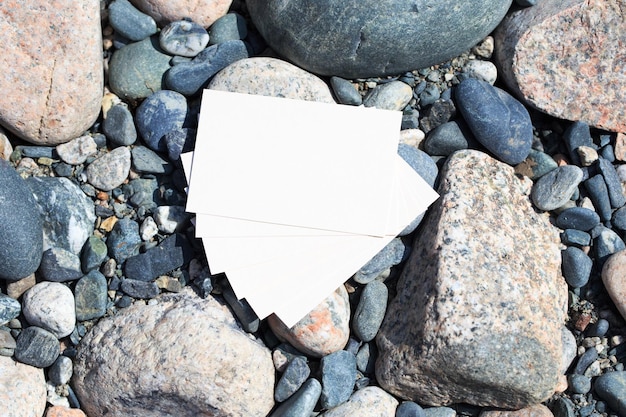 Biała kartka leży na stosie kamieni na plaży.