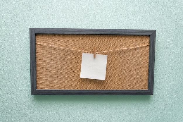 biała kartka papieru w kształcie kwadratu zawiesza się na tablicy na spinaczach do bielizny makieta wolnej przestrzeni