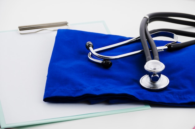 Zdjęcie biała księga w schowku; stetoskop i rękawiczki chirurgiczne na białym tle