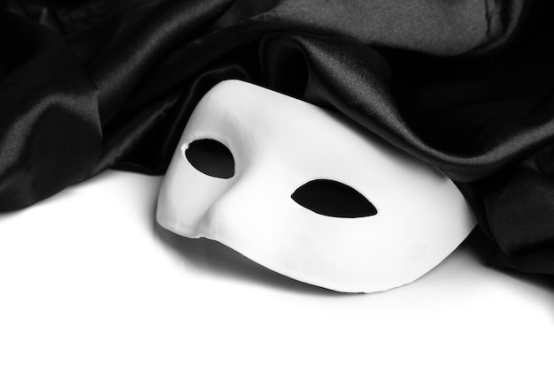 Zdjęcie biała maska i czarna jedwabna tkanina na białym tle