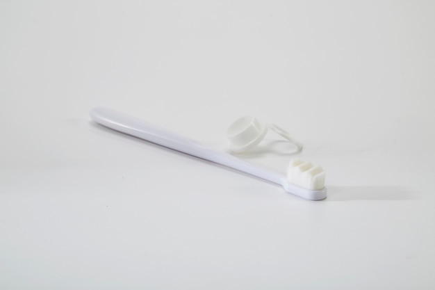 Biała plastikowa szczoteczka do zębów z białym stolikiem z włosia