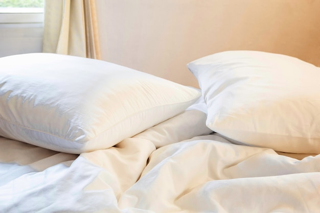 biała poduszka i koc z marszczonym brudem na łóżku