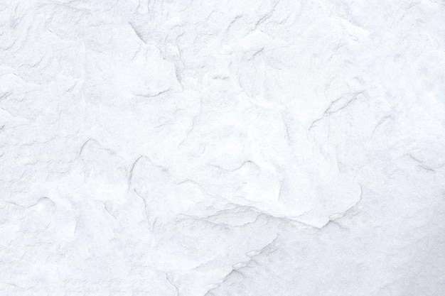 Biała powierzchnia ściany z teksturą białego kamienia, szorstki odcień szarości. Użyj tego jako tapety lub obrazu tła. Rockowe tło. Jest puste miejsce na tekst.