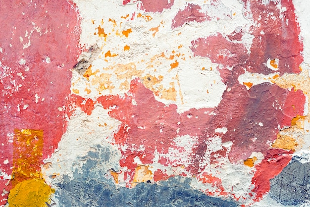 Biała ściana z łuszczącą się czerwoną farbą
