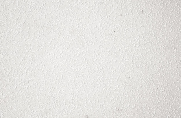 Biała ściana z teksturowaną powierzchnią i czarną plamą