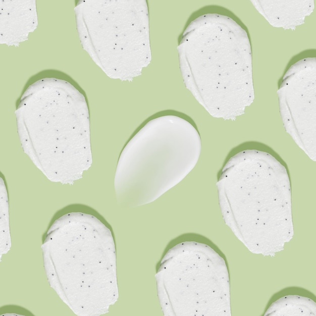 Biała śmietanka rozmazuje wzór na zielonym tle Piękno tekstury Próbka produktu kosmetycznego