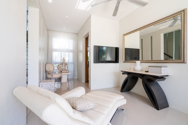 Biała sofa, wentylator sufitowy i telewizor w salonie willi przy basenie, domu. dom, mieszkanie i mieszkanie