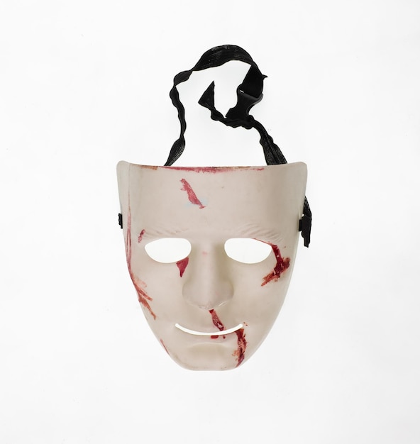 Zdjęcie biała teatralna maska z krwią na białym tle