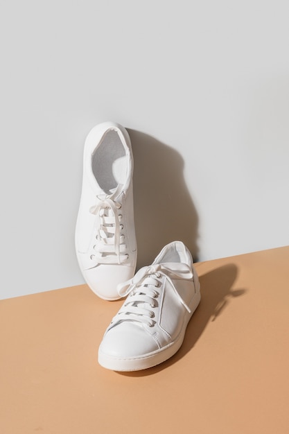 Białe buty damskie nowe na szarym i beżowym tle