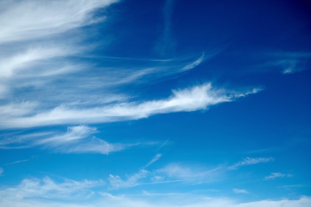 Białe chmury o nietypowym kształcie na letnim błękitnym niebie