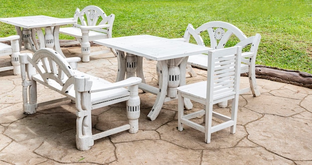 Białe drewniane krzesło i stół w stylu retro w kawiarni na trawniku