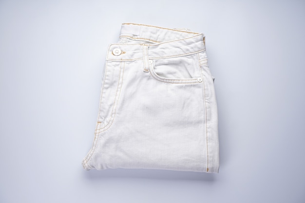 Białe dżinsy są ułożone w stos. Leżał na płasko.