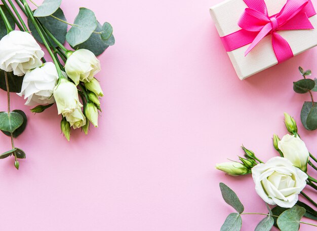 Białe eustoma kwiaty i pudełko na różowym tle