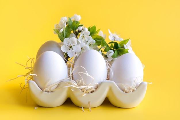 Białe jaja kurze z kwiatami w porcelanowym pudełku. Święta Wielkanocne. Wiosna. Ścieśniać.