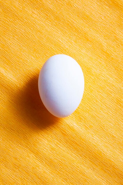białe jajko na żółtym tle