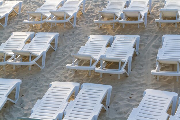 Białe leżaki na plaży.