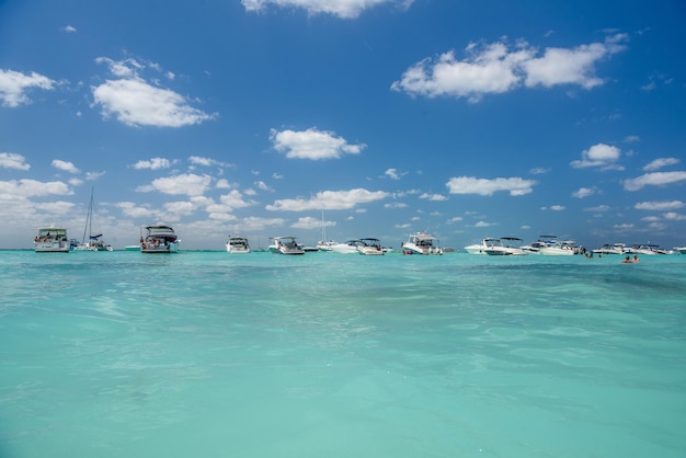 Białe łodzie motorowe i jachty w turkusowym lazurowym morzu karaibskim Wyspa Isla Mujeres Morze Karaibskie Cancun Jukatan Meksyk
