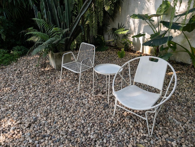 Białe metalowe krzesło i stół nastawiony na kawę