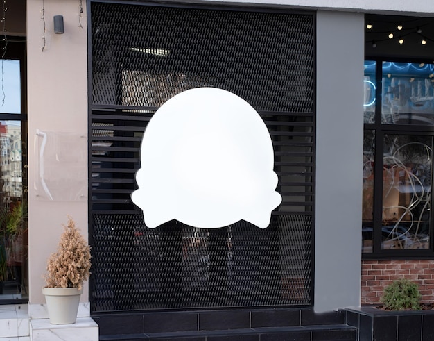 Białe okrągłe logo na zewnętrznej ścianie budynku do projektowania makiet