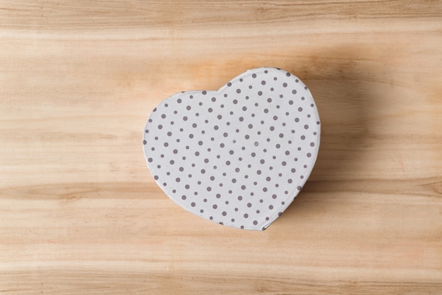 Białe pudełko w kształcie serca na drewnie. Symbol miłości