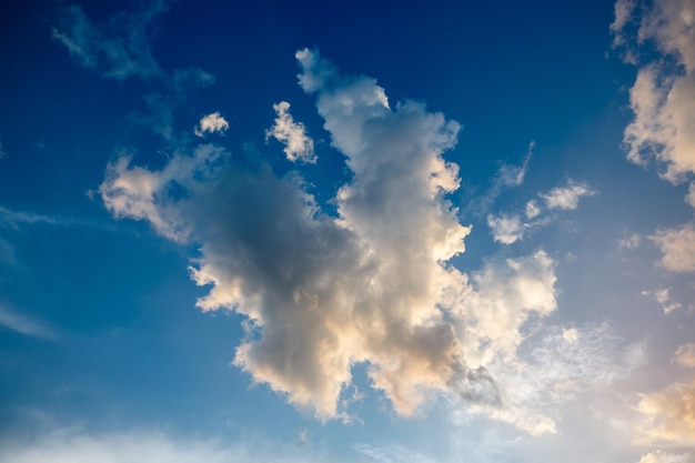 Białe puszyste chmury burzowe cumulonimbus w głębokim błękitnym niebie