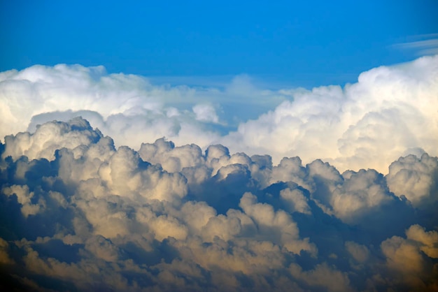 Białe puszyste chmury cumulonimbus formujące się przed burzą na letnim niebieskim niebie Zmieniająca się burzowa pogoda w chmurach