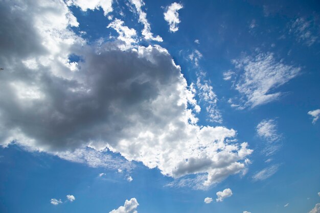 białe puszyste chmury w słoneczny dzień na błękitnym niebie w letni dzień