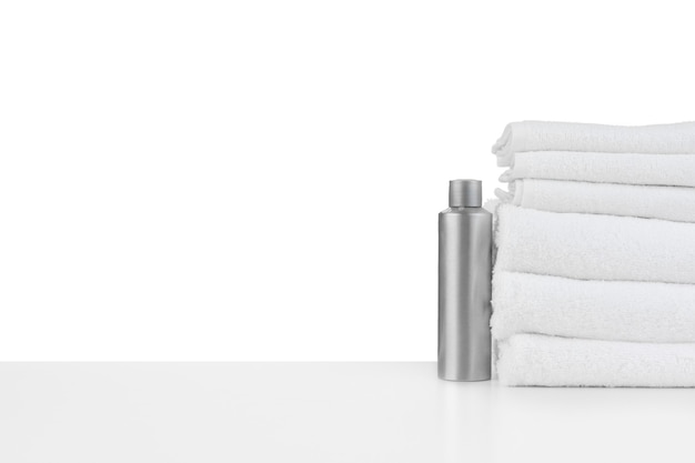 Białe ręczniki i kosmetyki do pielęgnacji skóry spa na białym tle