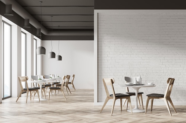 Białe wnętrze kawiarni z drewnianą podłogą, okrągłymi białymi stołami i szarymi i drewnianymi krzesłami. Fragment białej ściany. Makieta renderowania 3D