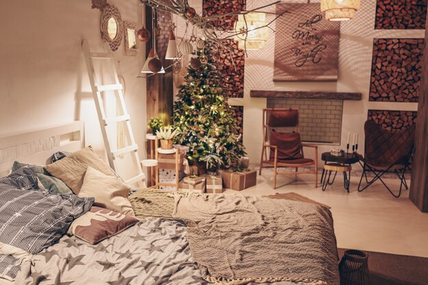 Zdjęcie białe wnętrze sypialni w stylu skandynawskim z ozdobną choinką